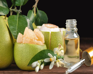 a bottle of essential oil next to fruit